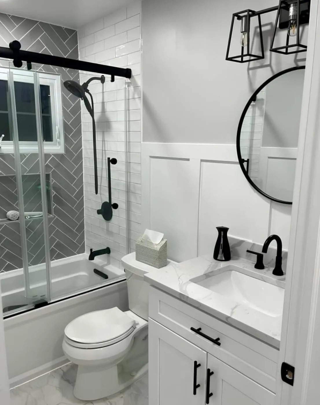 Remodeled bathroom with herringbone tile shower and black fixtures