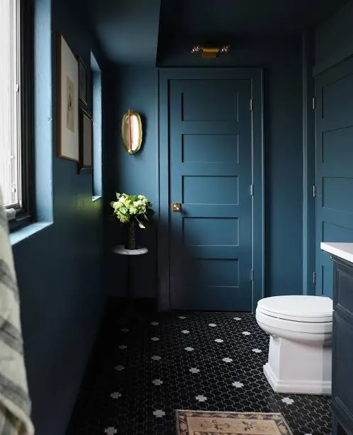 Dark teal powder bathroom with penny tile floor