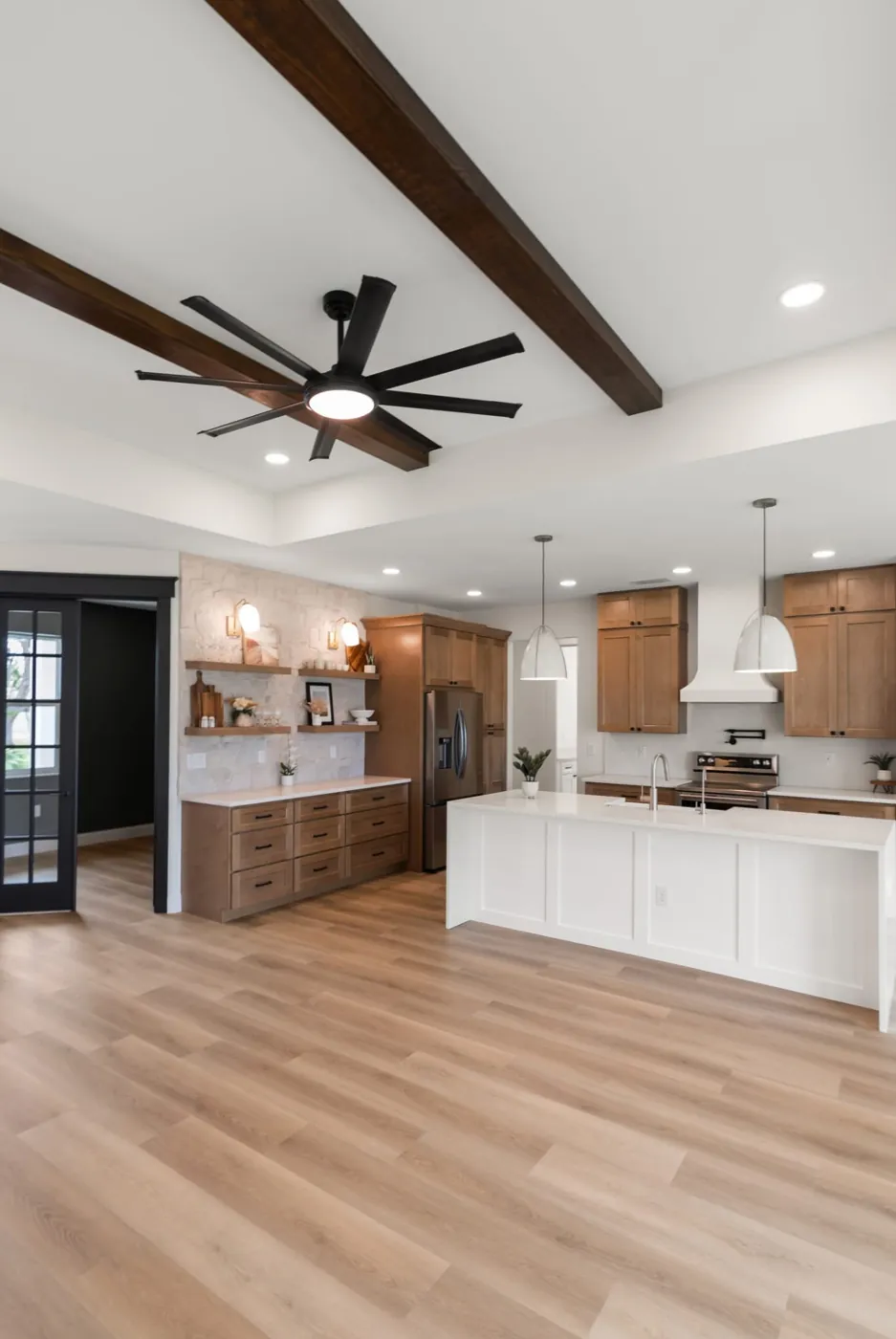 Open kitchen with wood ceiling beams and white island