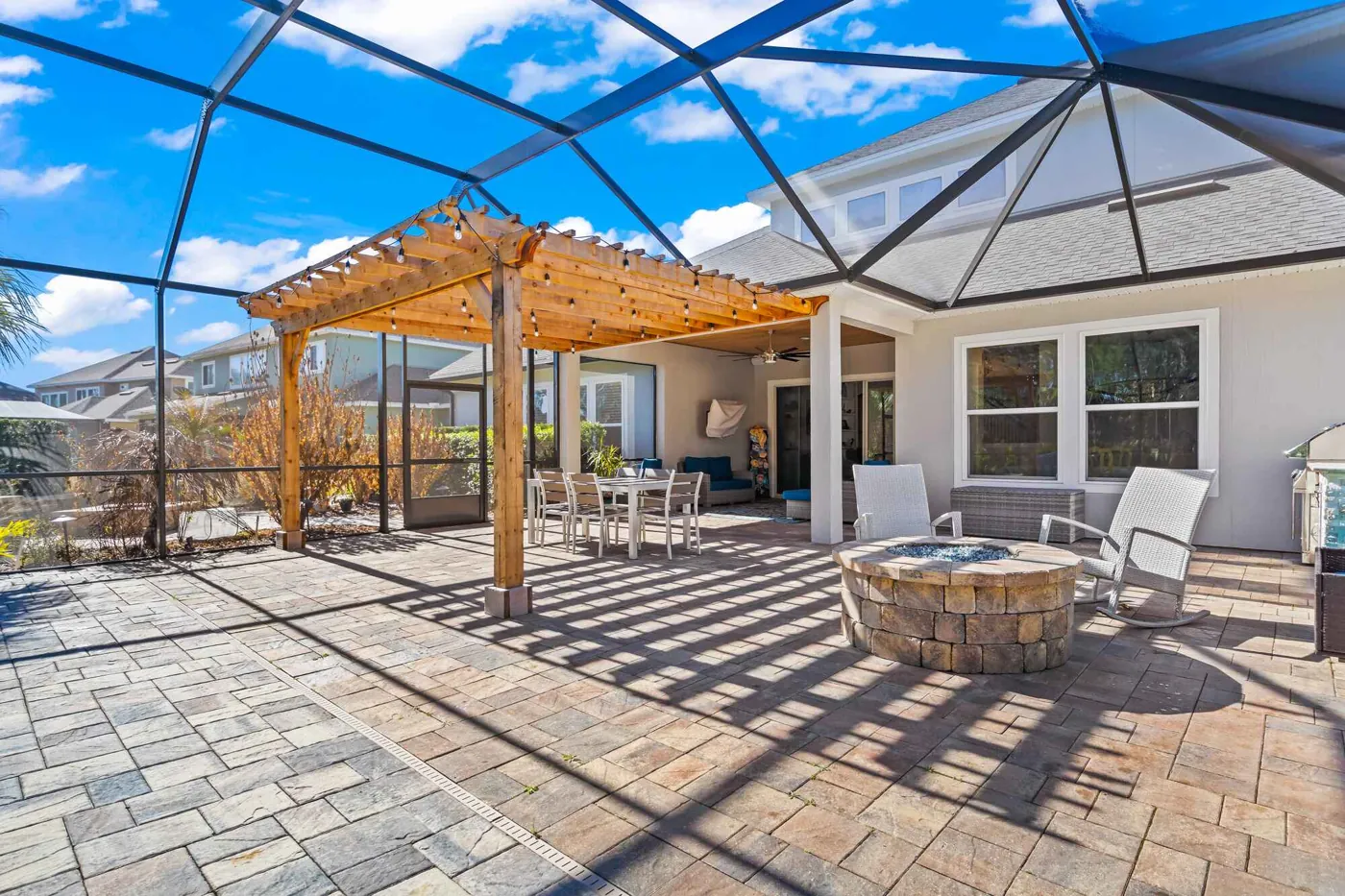 Screened patio with pergola, pavers, and fire pit