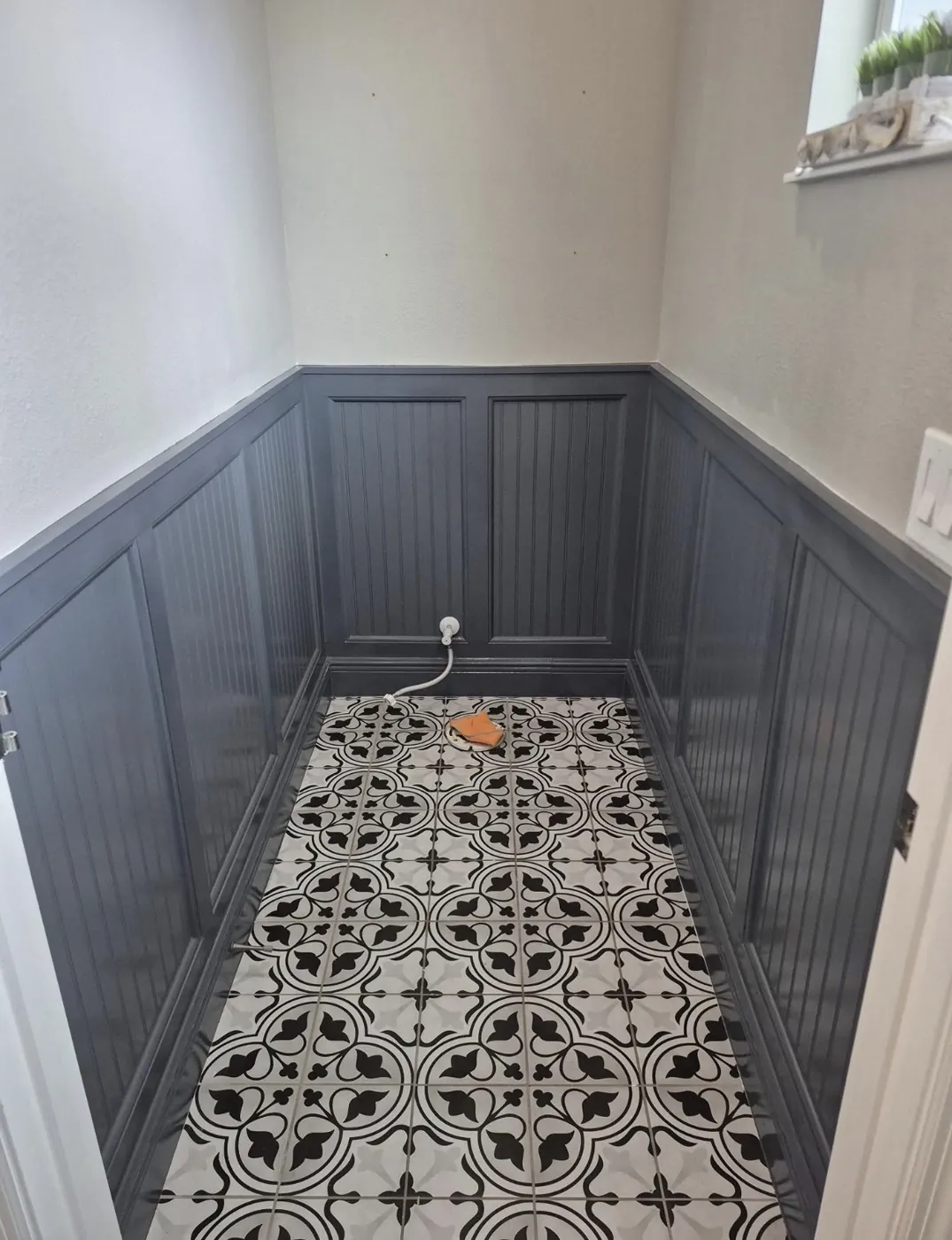 Painted wainscoting hallway with patterned tile floor