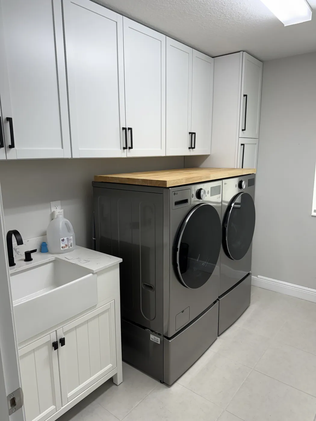 Remodeled laundry room with farm sink and custom cabinets